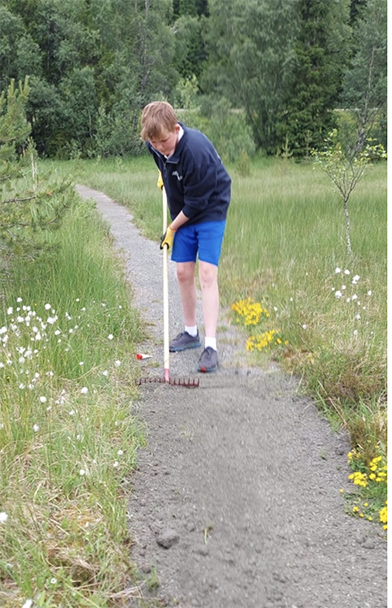 Ole Christian Sagen (15) fordeler sa° grusen utover pa° stien - Klikk for stort bilde